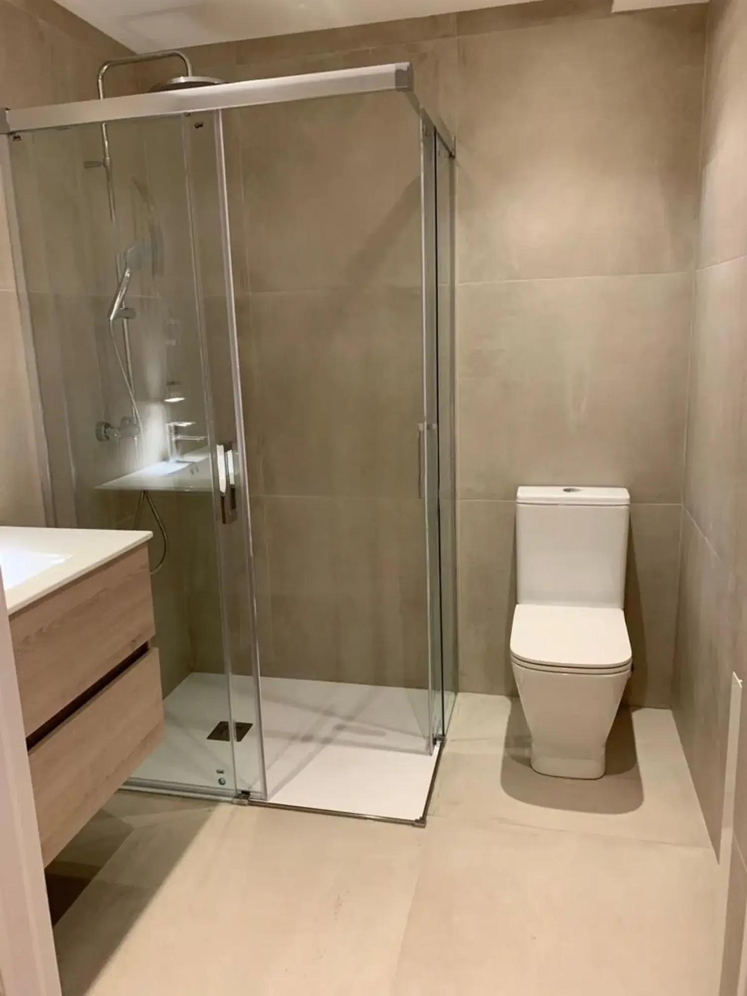 Baño con ducha a ras de suelo y mueble suspendido en Comarruga