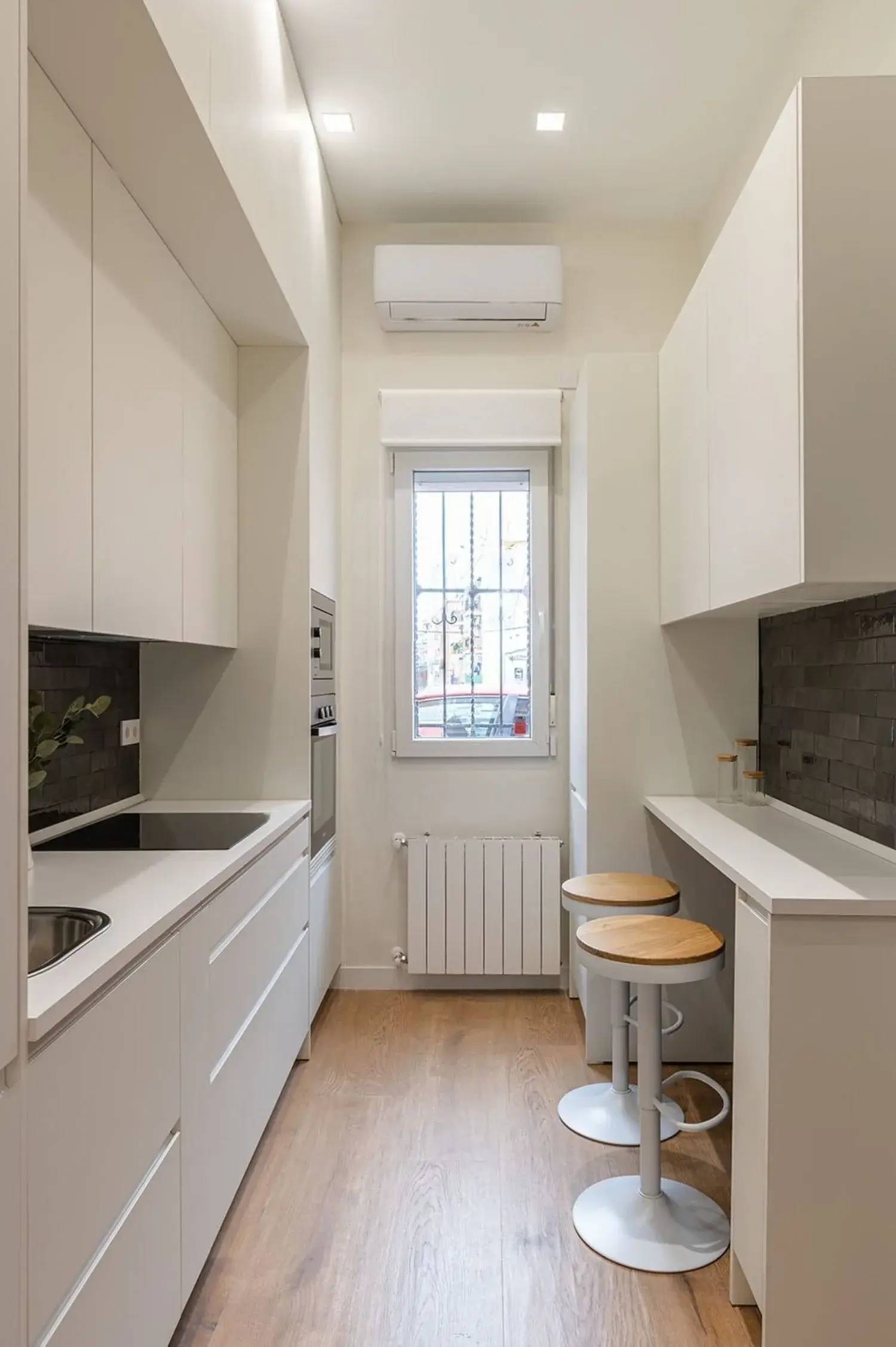 Cocina blanca lineal con barra, reforma de cocina en Coma-ruga