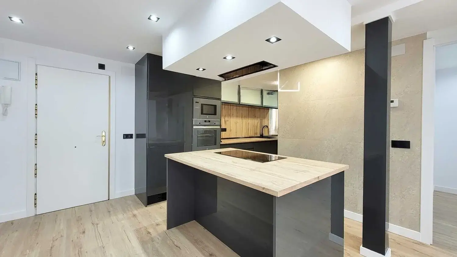 Cocina abierta con isla y encimera de madera reformada en Comarruga