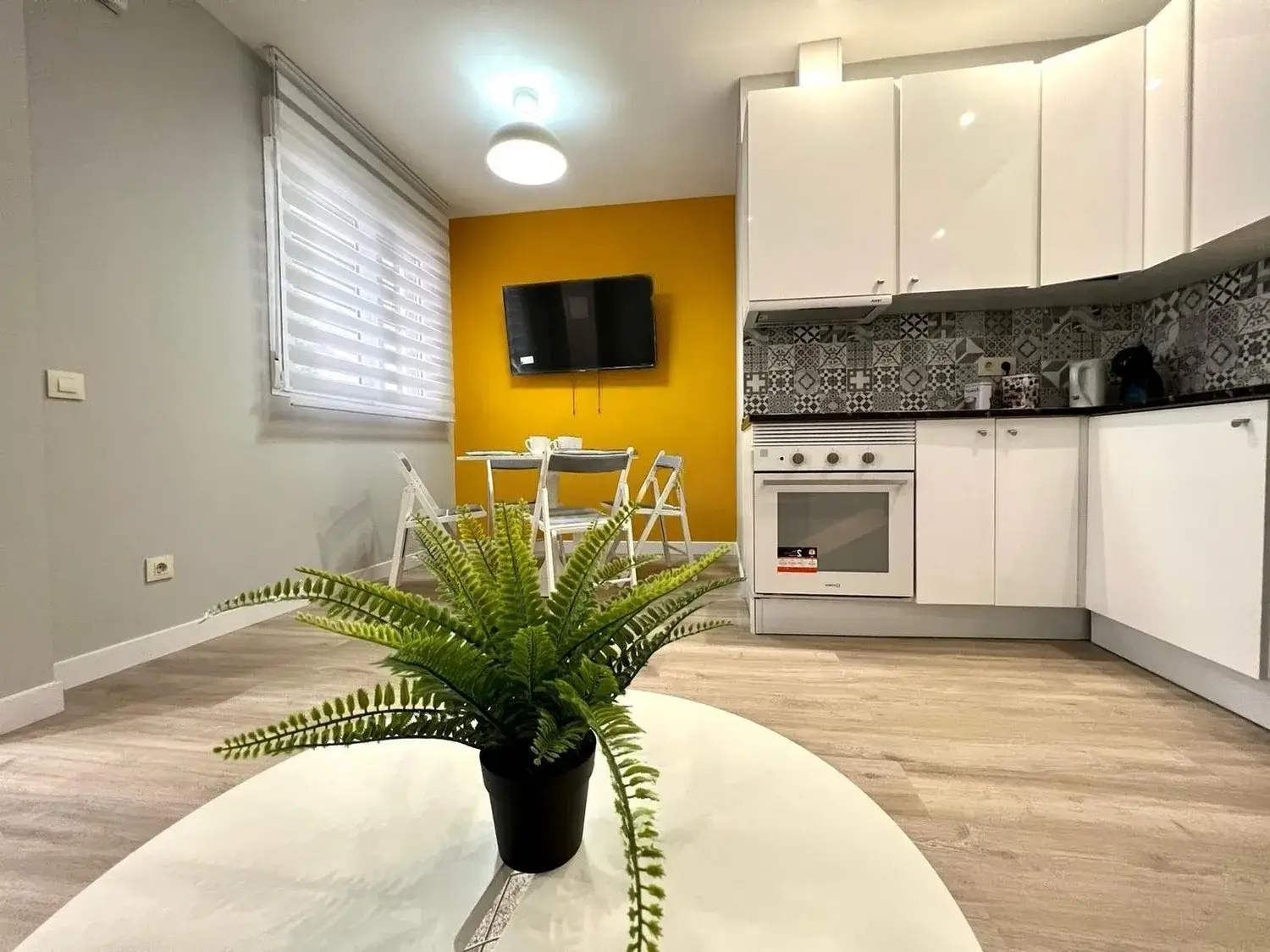 Salón con cocina abierta tras la reforma de un piso en Coma-ruga